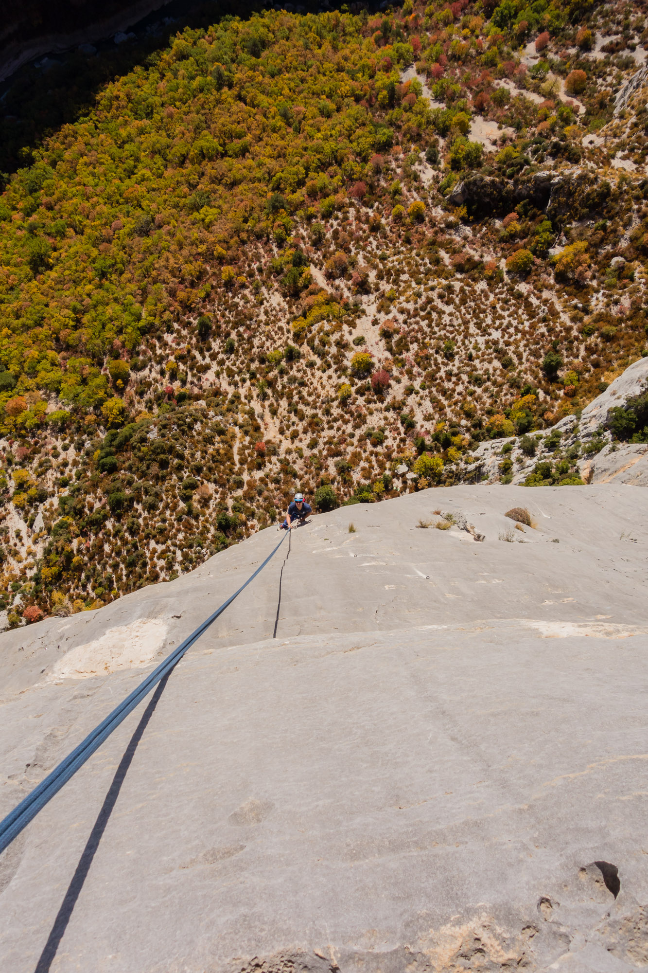 Andy at the hanging stance after abseiling in to the world's most exposed 6a; Wide is Love