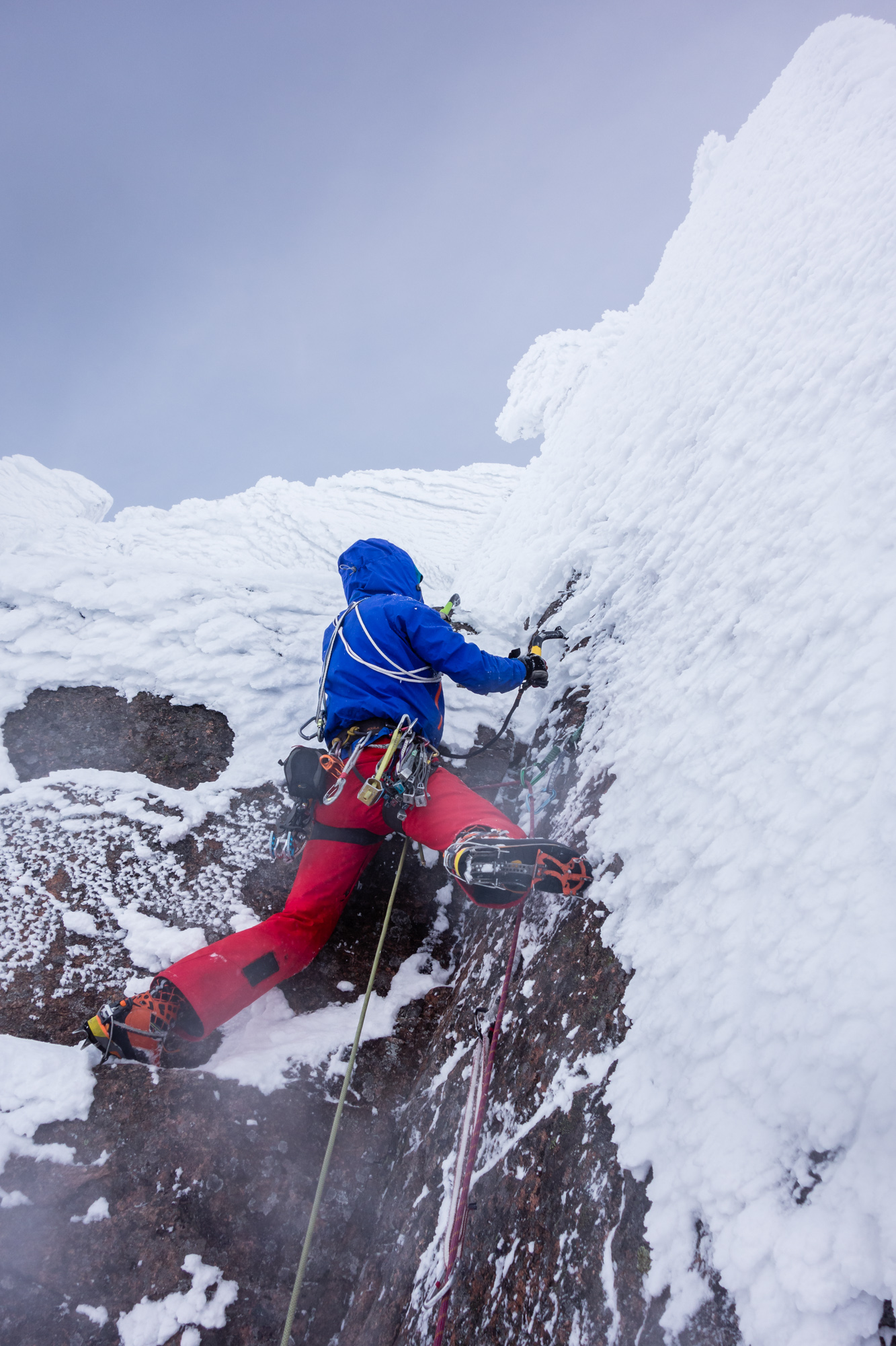 Andy clearing his way up the crux corner - this section was covered completely in thick rime, which hid all the holds and gear placements.