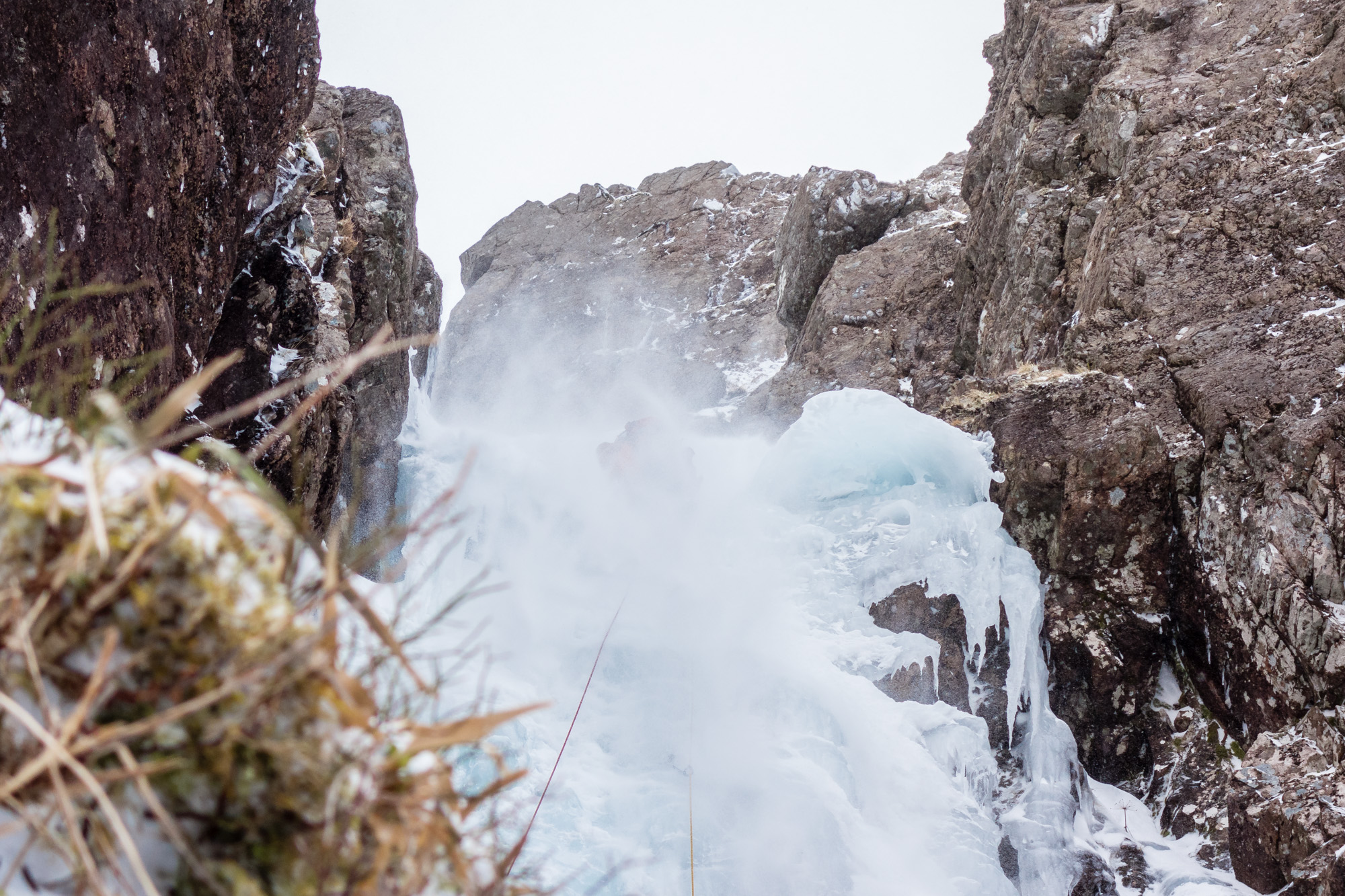 From the shelter of the belay Ric captures a refreshing spindrift shower, which felt like lasted forever! Photo credit: Ric Hines